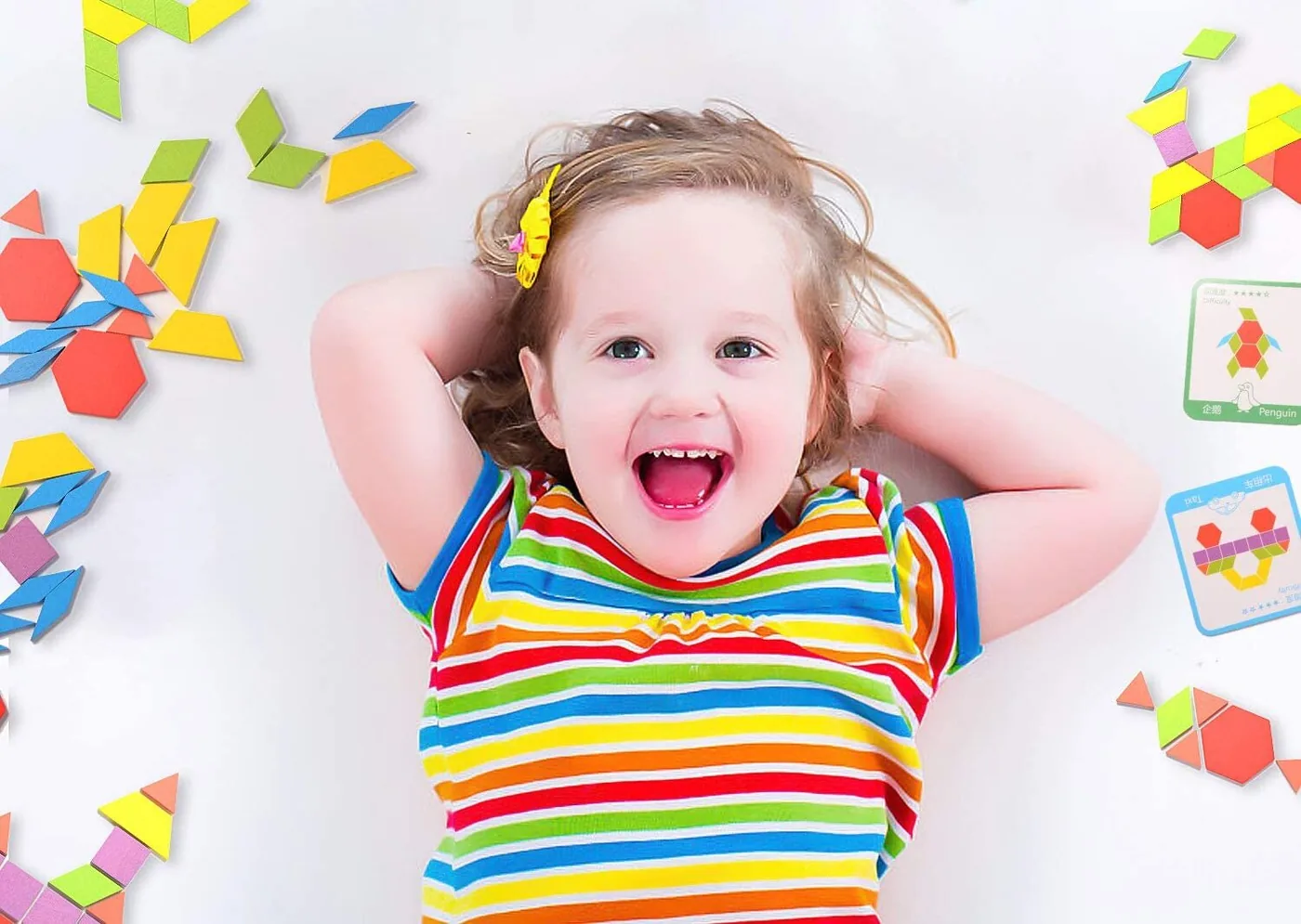 Un enfant joyeux se trouve entre plusieurs figures de type tangram