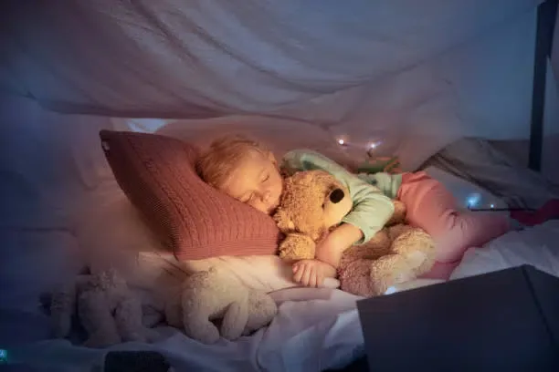Une petite fille dormant dans un modèle de lit cabane Montessori