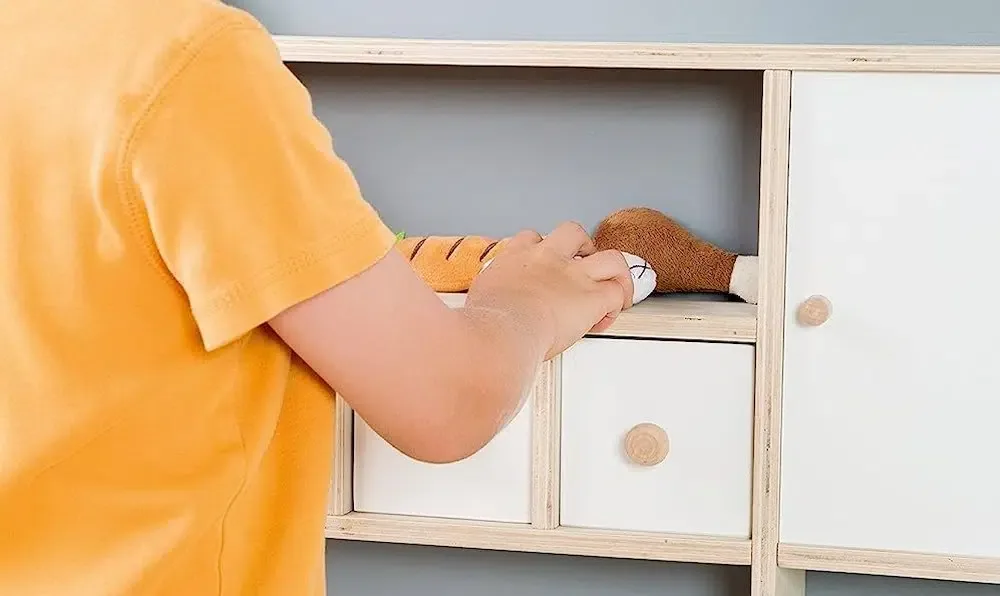 Un enfant jouant avec une marchande en bois