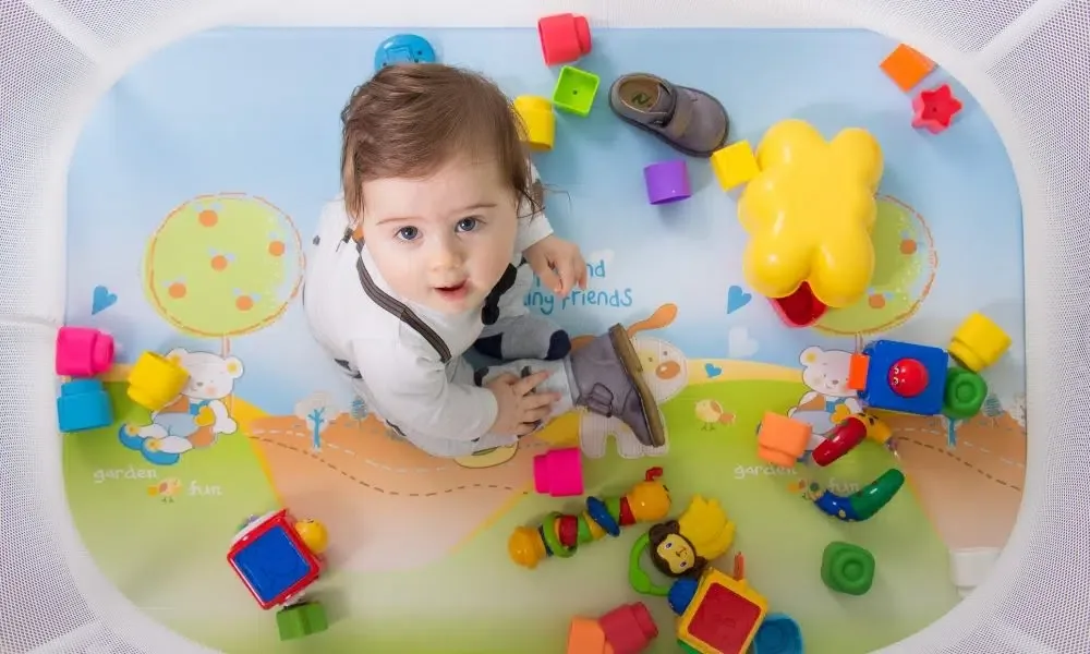 Un bébé dans un parc avec de nombreux jouets