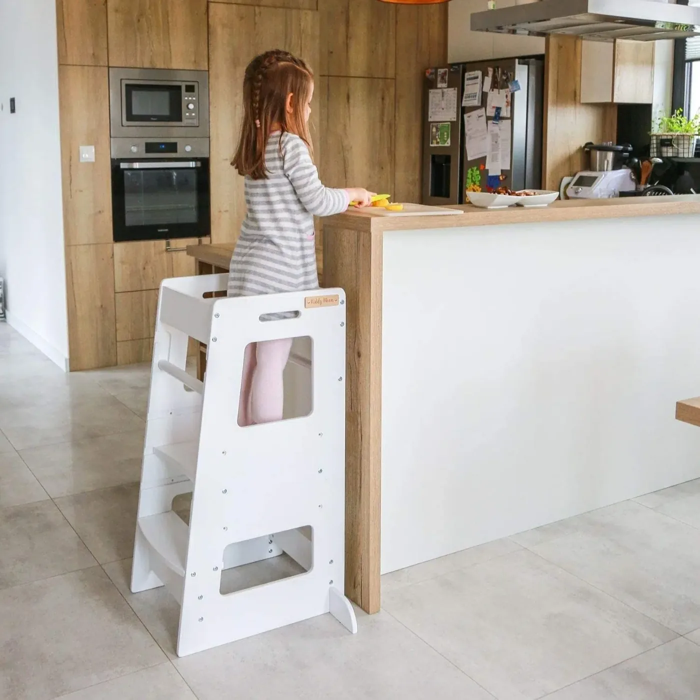 petite fille faisant la cuisine sur une tour d'observation Montessori