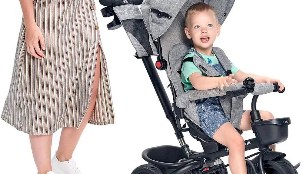 Mère avec son enfant assise sur un tricycle Kinderkraft